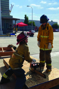 Participants practicing firefighter skills such as venting a roof at LAFD girls campt